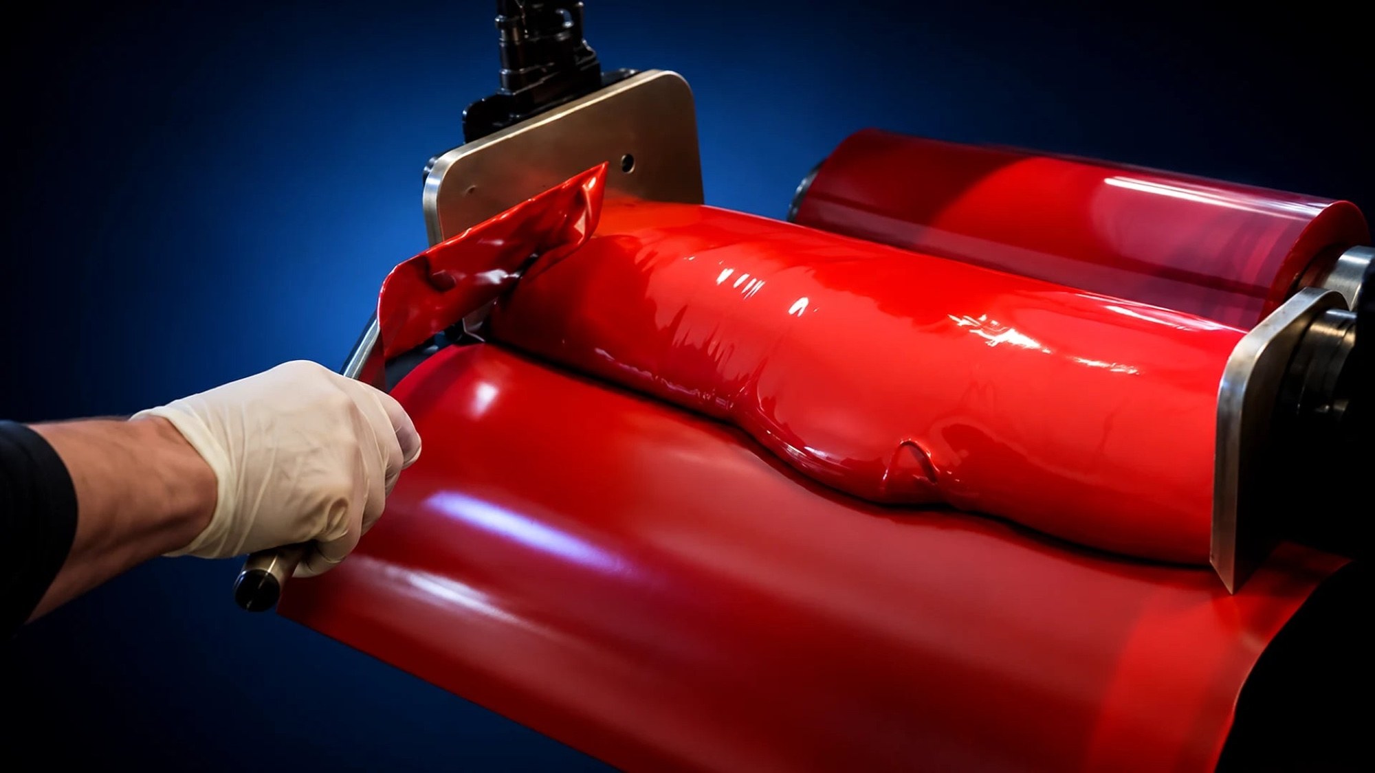 Vibrant red plastisol ink milled on a roller — Total Ink Solutions manufactures its own ink in-house